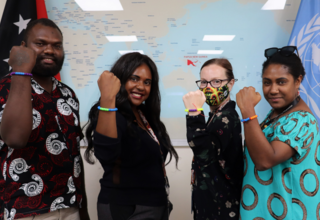 UNFPA's Isaac, Bronwyn, Rachel, and Rosemary show off their bracelets at a Menstrual Hygiene Day event in Port Moresby.