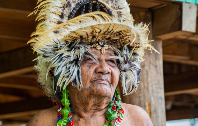 Older woman from Central Province, Papua New Guinea, in traditional dress looking into middle distance.