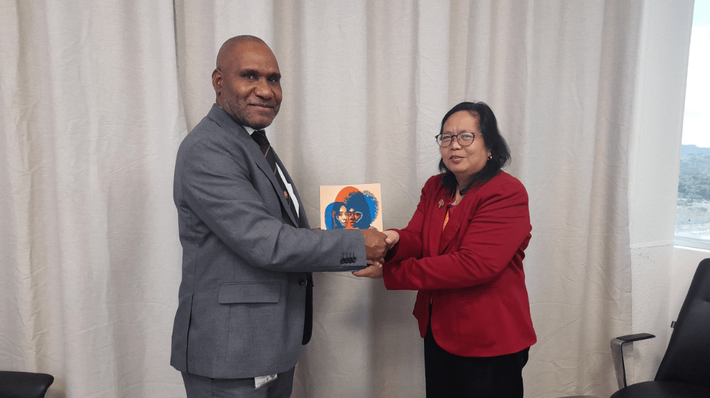 Department of Monitoring and Planning's First Assistant Secretary for the Macro Planning Division Mr. Sanja Pepae receiving SWOP Report 2024 from UNFPA Deputy Representative Dr. Rena Dona.