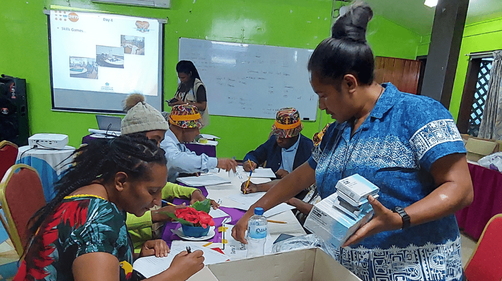 People stand around table counting boxes of medical stock.