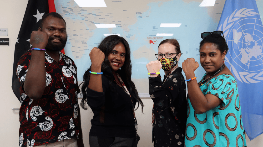 UNFPA's Isaac, Bronwyn, Rachel, and Rosemary show off their bracelets at a Menstrual Hygiene Day event in Port Moresby.