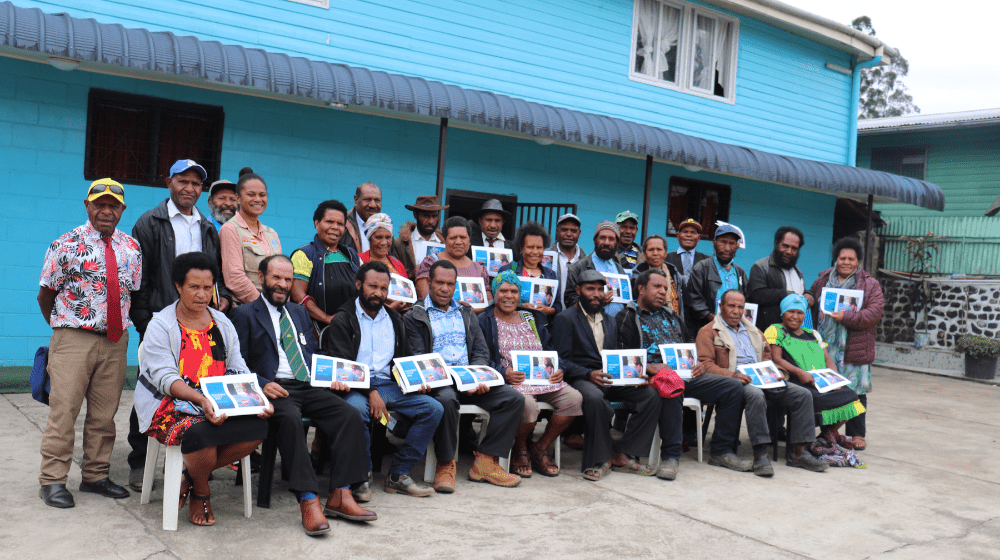 Group of 60 people holding certificates and facing camera. 